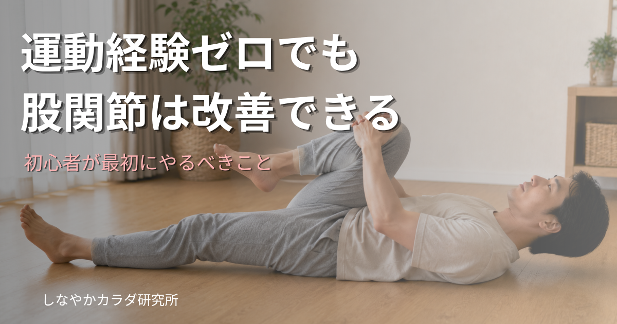 カジュアルな服装で木製の床に仰向けになり、膝を胸に引き寄せてストレッチをしている人物。運動初心者向け股関節ストレッチのイメージ。