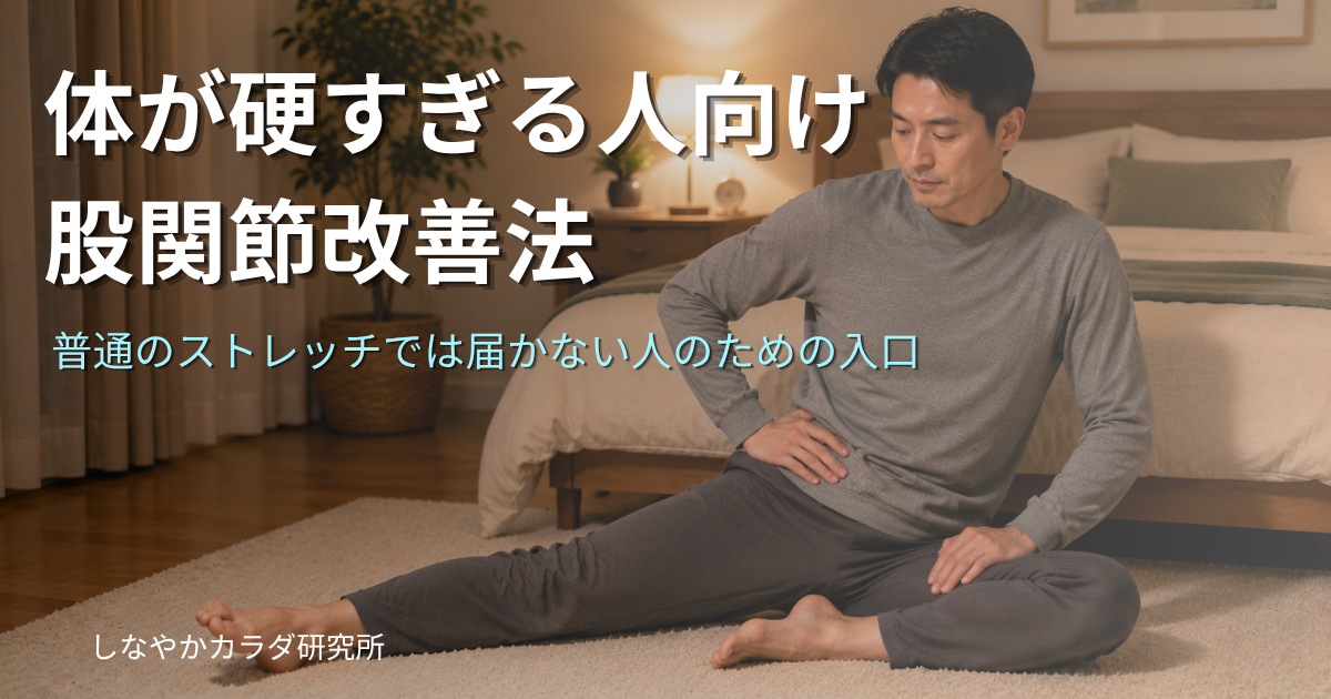 ルームウェアを着た人物が寝室のカーペットの上で、太ももに手を当てながらゆったりとした股関節ストレッチをしている様子。